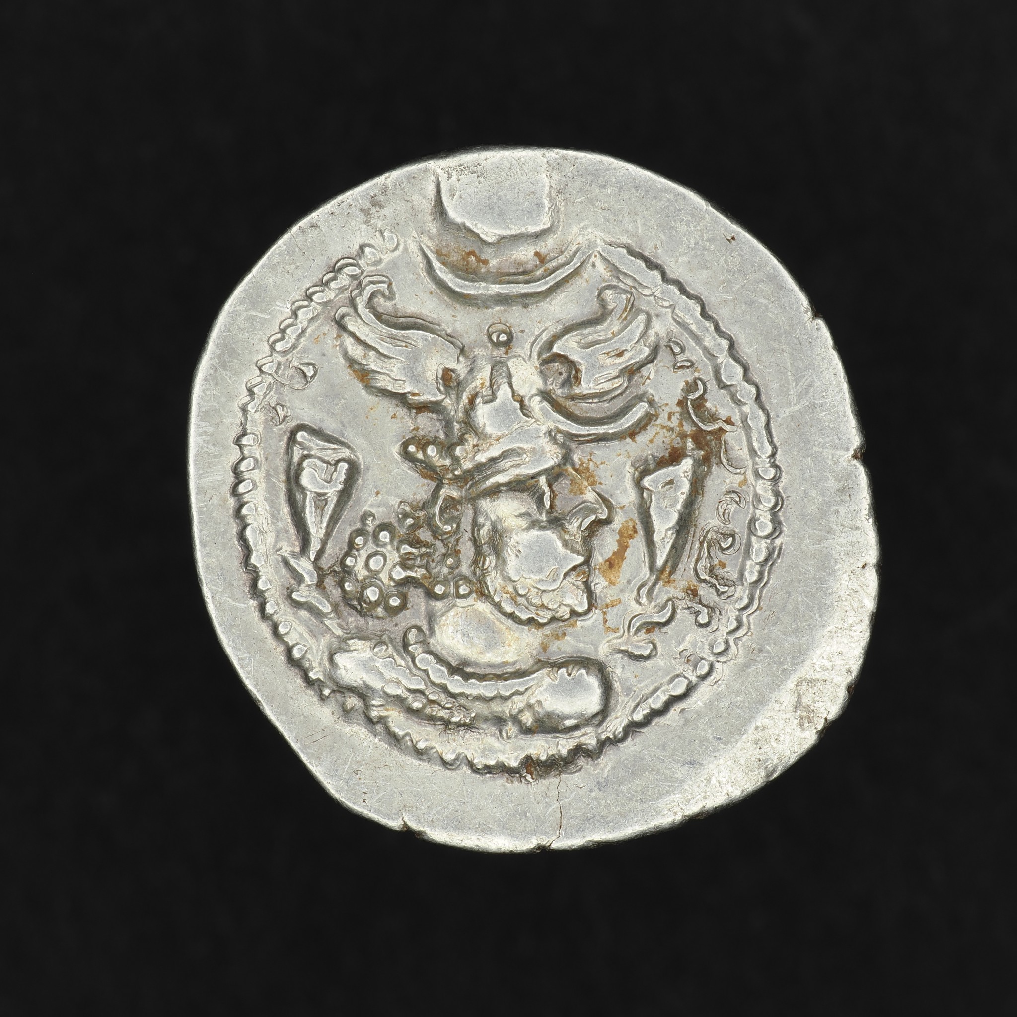 Obverse of Silver Drachm of Sasanian King Peroz I showing crowned bust with winged headdress